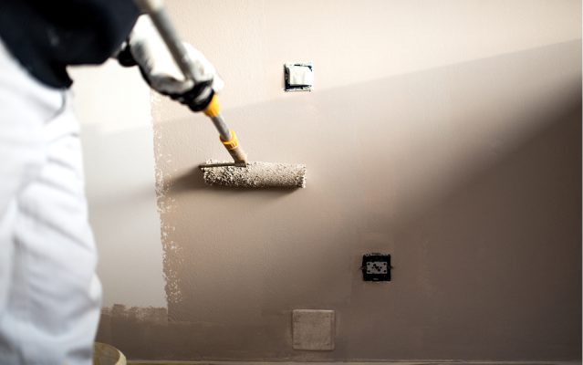 målare som målar vägg med roller